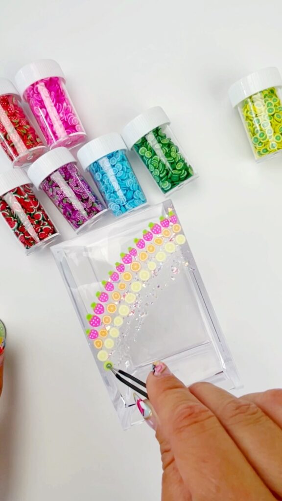 Using tweezers to add the design to this DIY craft room storage container