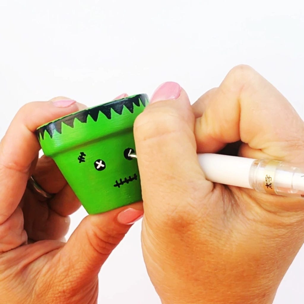 Painting technique for Frankenstein on a terracotta flower pot - use a paint maker to create eyes