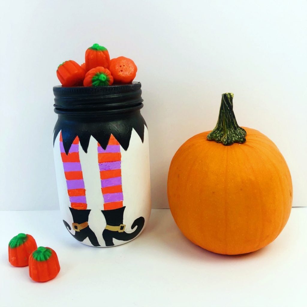 Witches legs painted onto a mason jar for Halloween