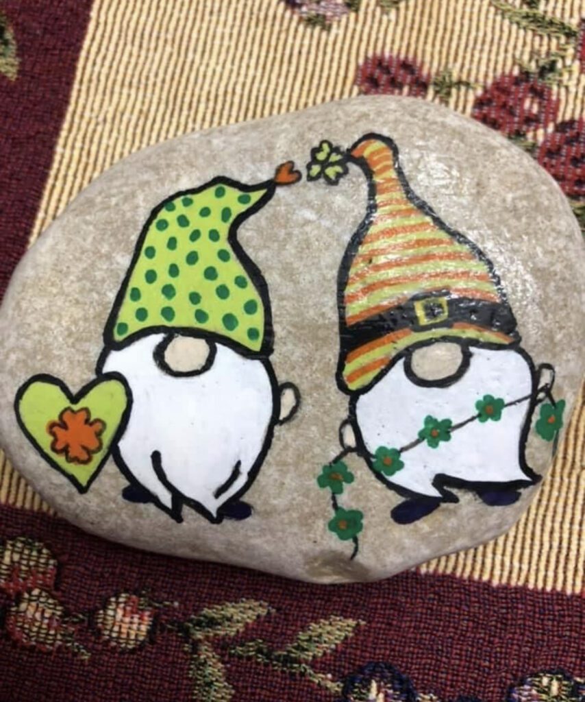 Idea for Gnome Painted Rocks - there are two gnomes on the rock, one has a green heart the other a garland