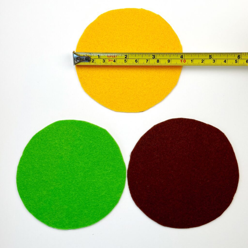 Three 4 inch felt circles cut out in yellow, green, and brown