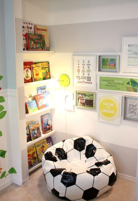 Sports themed idea for kids reading nooks - there are floor to ceiling bookshelves, artwork on the other wall, and a soccer ball bean bag chair